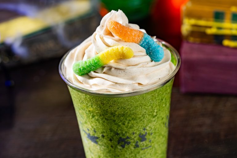 Oogie Boogie Slushy: Frozen apple cider topped with cinnamon whipped cream and sour gummy candy (Non-alcoholic) (Available during Mickey’s Not-So-Scary Halloween Party only)
