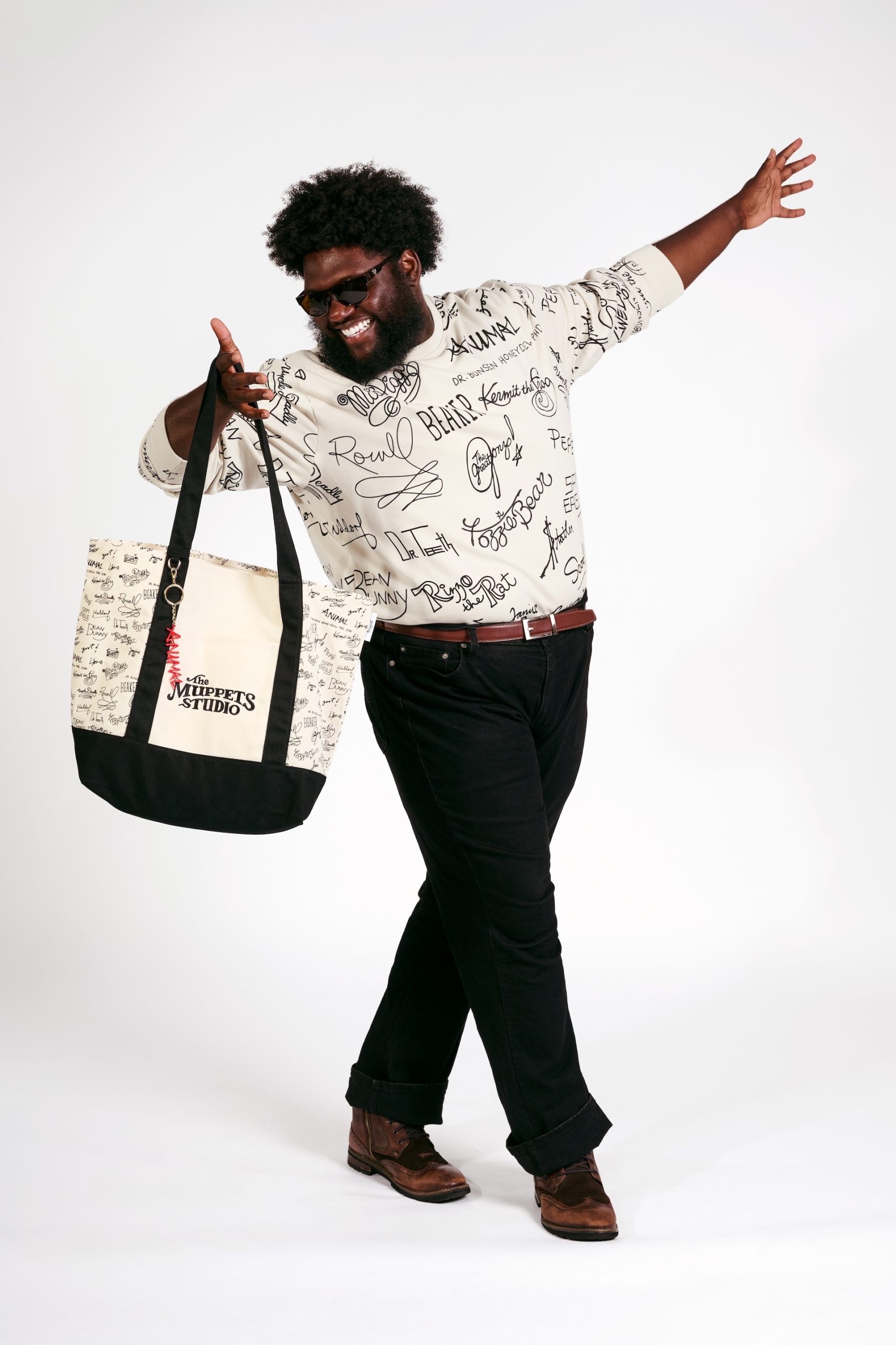 Model wearing a Muppets signature shirt and carrying The Muppets Studio tote bag