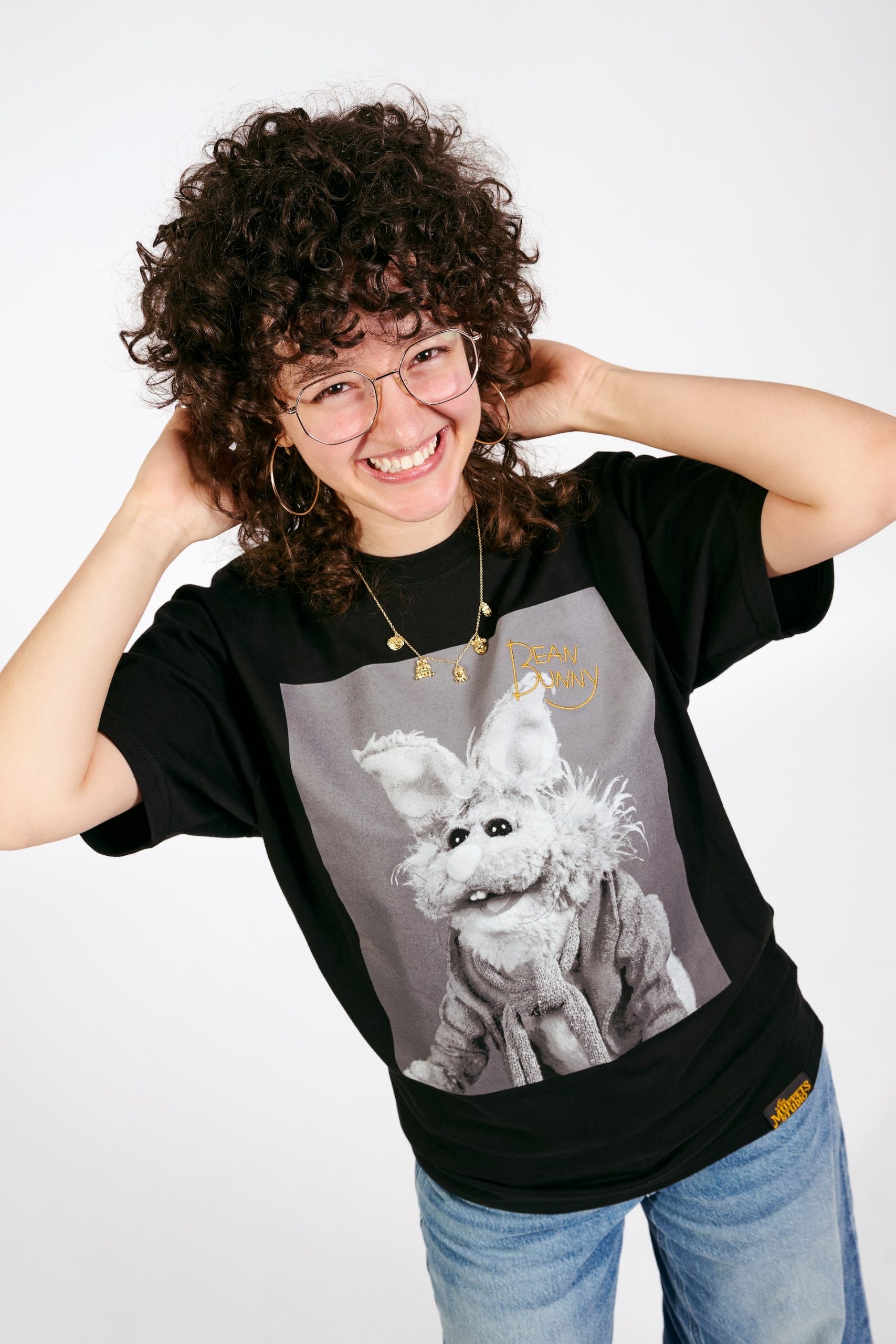 Model wearing a Bean Bunny graphic T-shirt and gold Muppets necklace