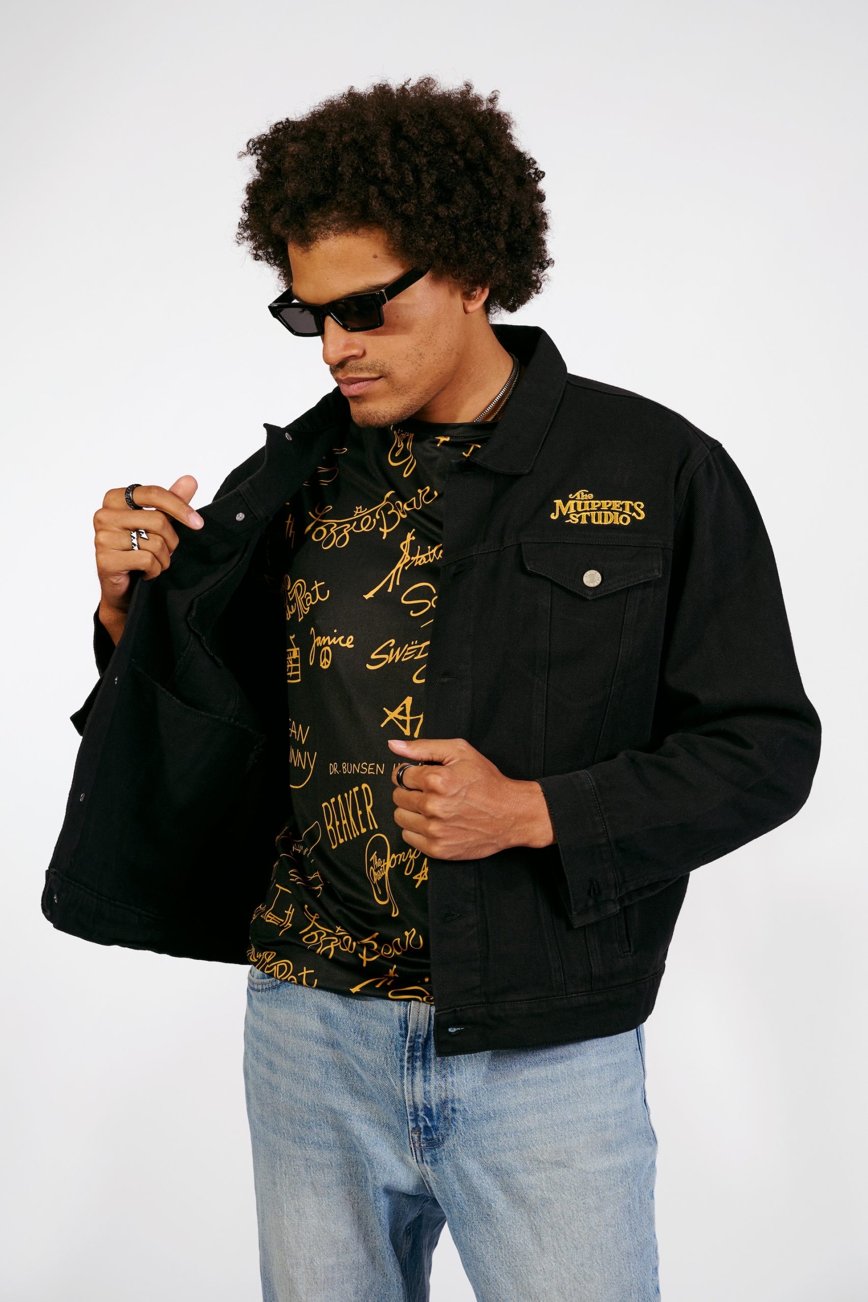 Front of a black denim jacket embroidered with The Muppets Studio logo