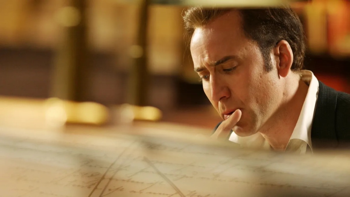 Nicolas Cage as Benjamin Franklin Gates studying a map in National Treasure