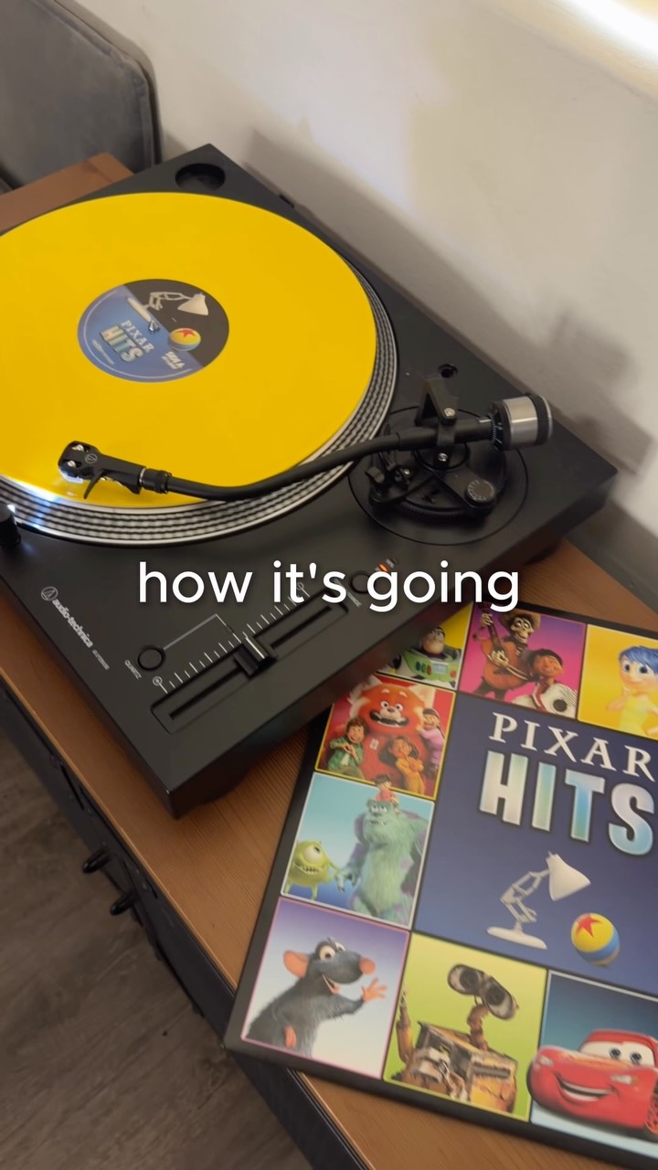 Yellow Pixar Hits vinyl record beside its blue album sleeve