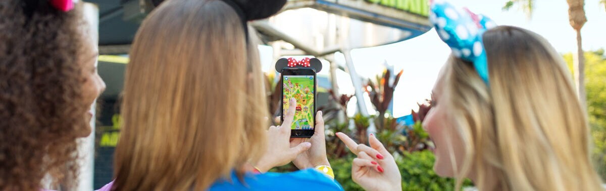 Guests use the Play Disney Parks app near Space Mountain at Disneyland
