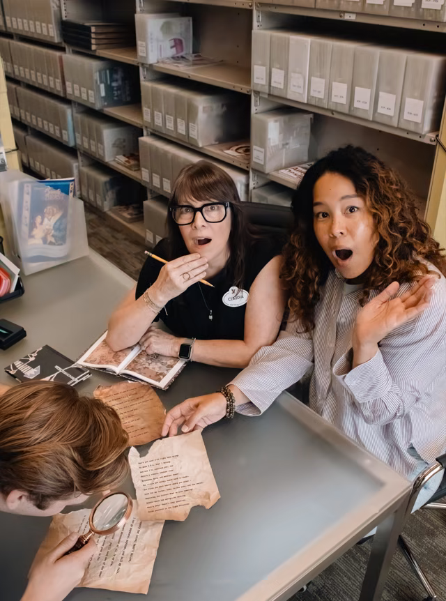 Imagineers examine riddle pages in the Walt Disney Imagineering archive