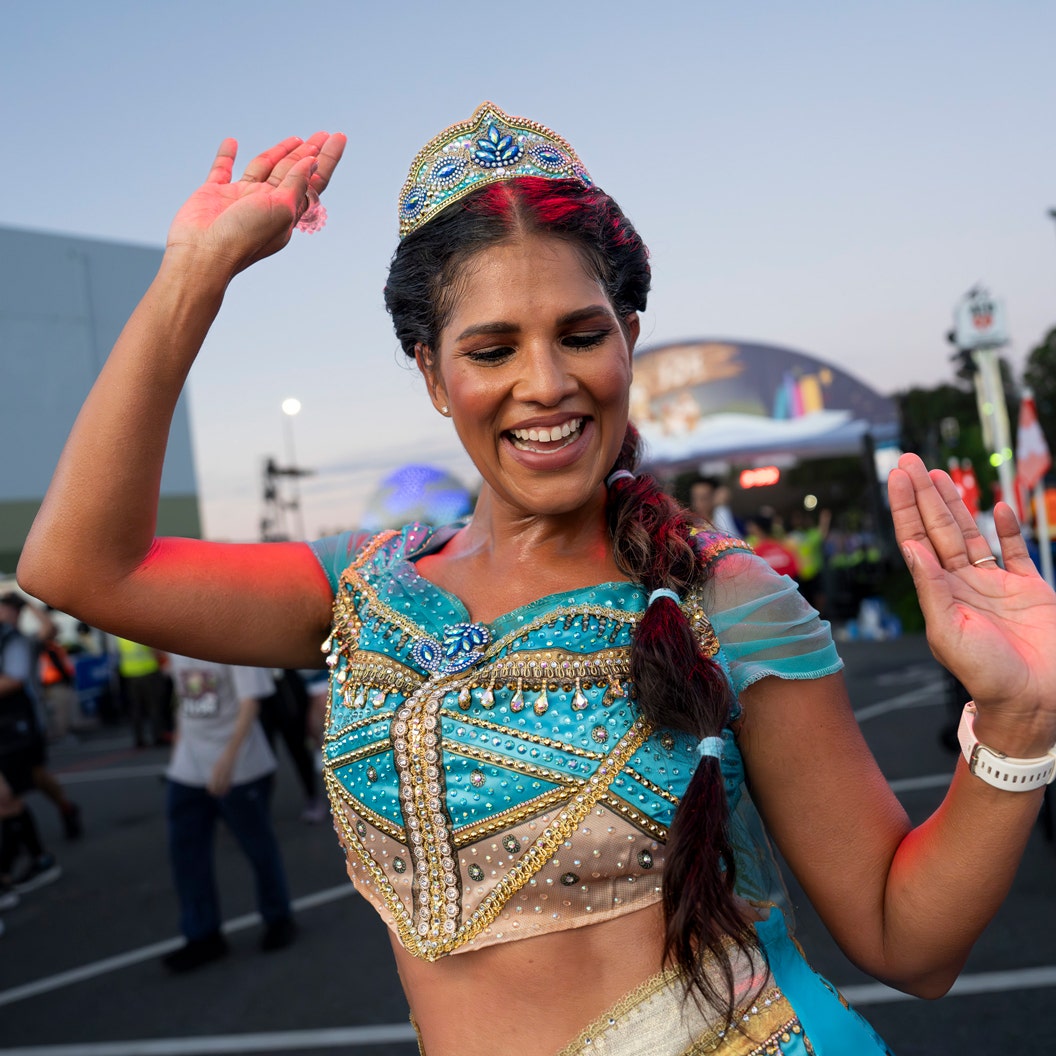 Runner dressed as Princess Jasmine waves during Disney Princess Half Marathon Weekend