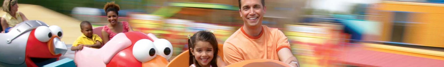 Families ride a colorful Sesame Place attraction