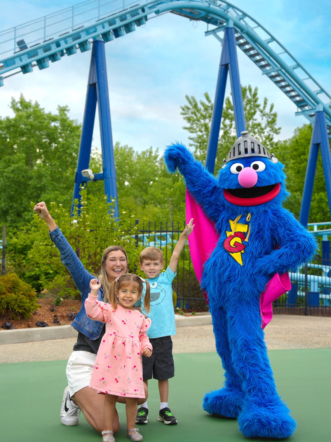 Grover poses with a family near a roller coaster at Sesame Place Philadelphia