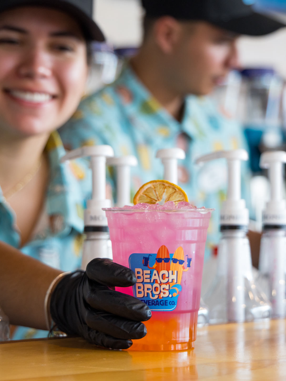 A Beach Bro's staff member holds a pink iced drink at Six Flags Great Adventure
