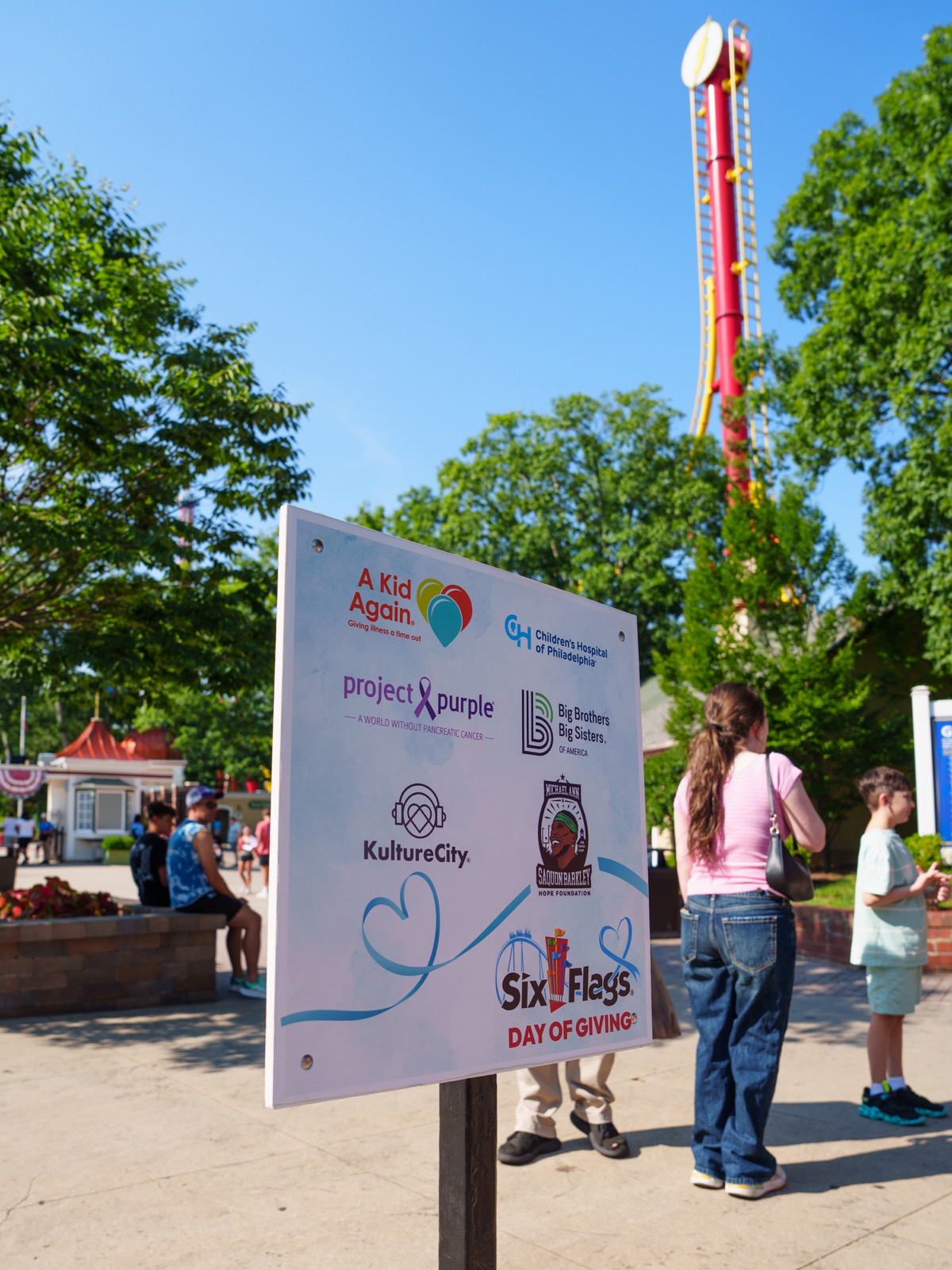 Day of Giving sign listing six nonprofit partners at Six Flags Great Adventure