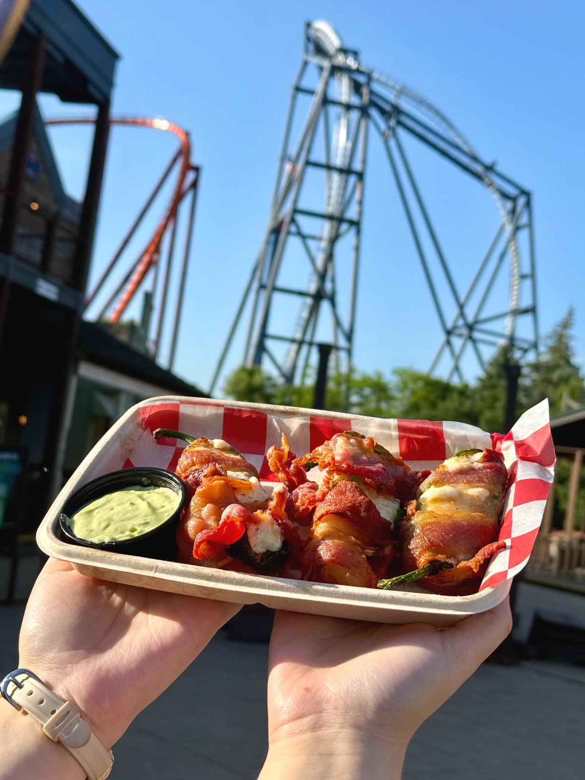 Bacon-wrapped peppers served in front of Six Flags Great America roller coasters