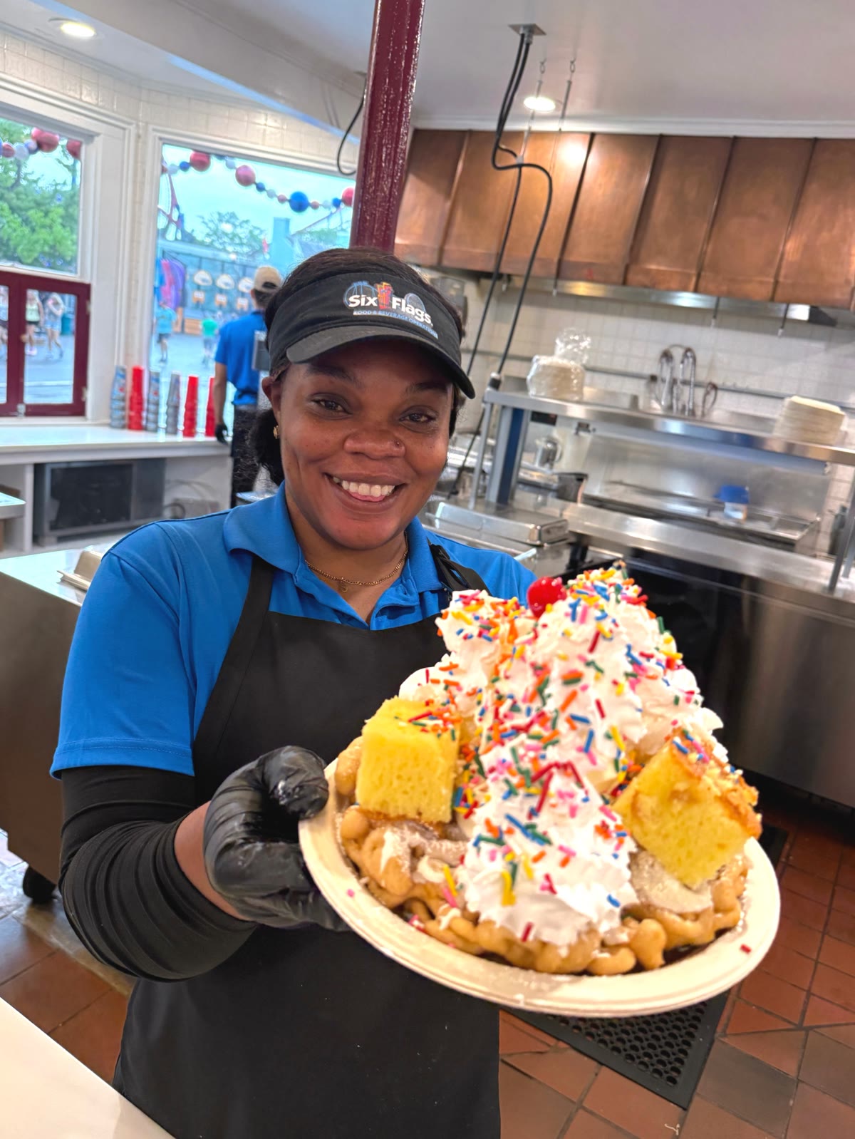 Six Flags Great America team member holding a birthday funnel cake