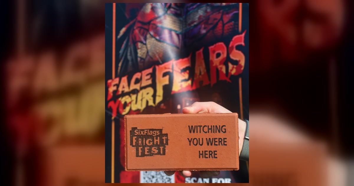 A personalized Fright Fest brick held in front of a Six Flags Great America Fright Fest sign