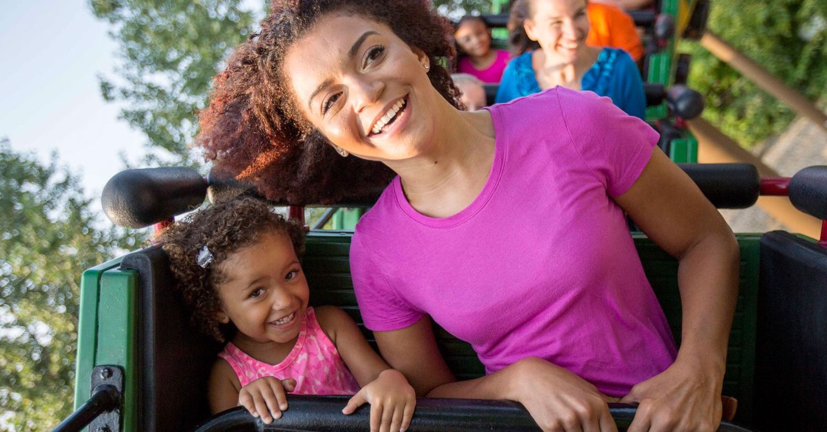 A family rides a Cedar Point roller coaster during a sunny park day