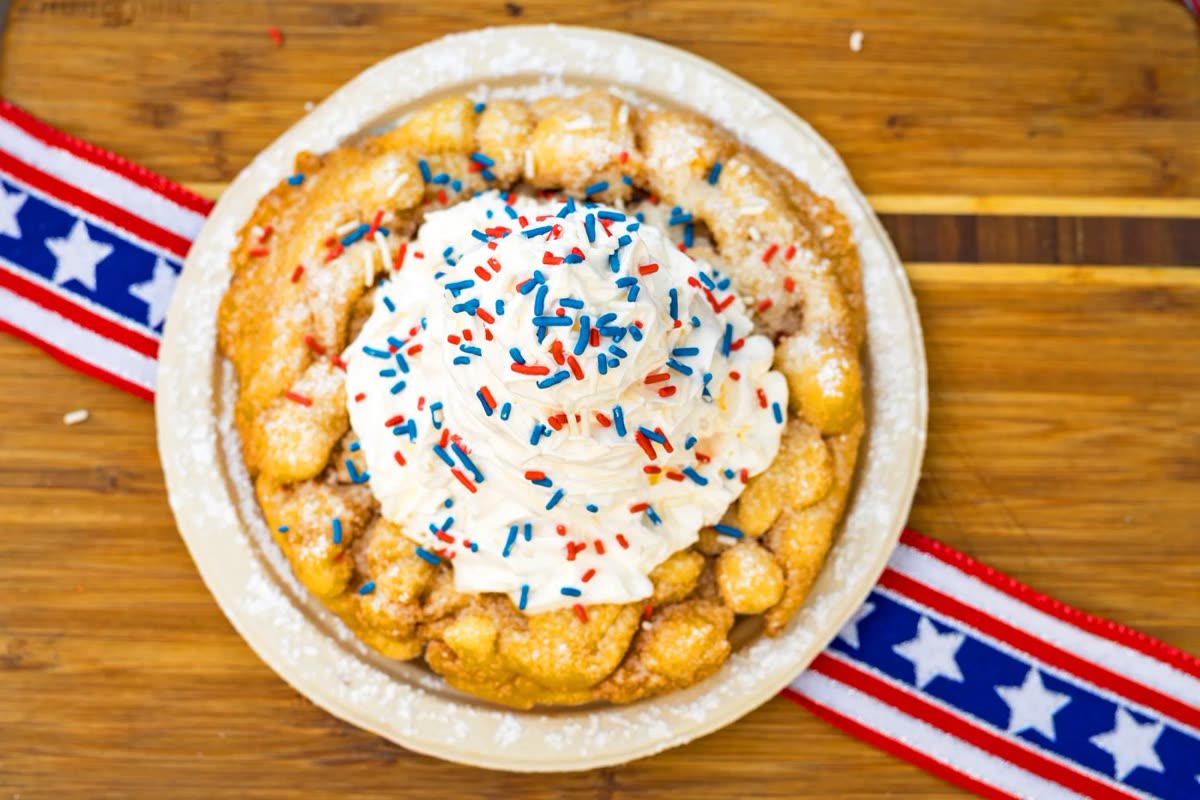 Funnel cake topped with vanilla ice cream and red, white, and blue candy