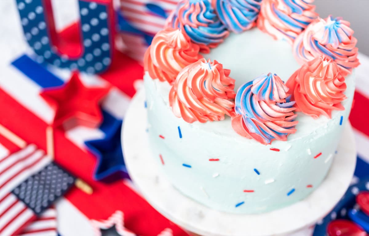 Red, white, and blue vanilla layer cake with buttercream and sprinkles