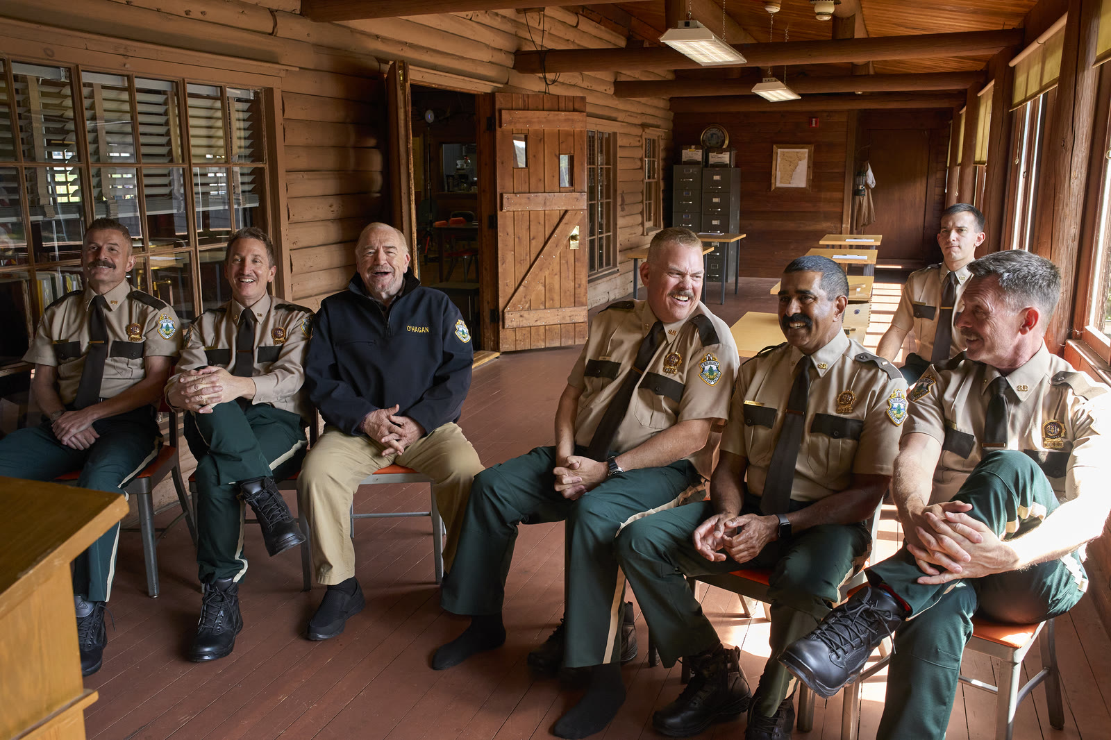The Super Troopers and Captain O'Hagan sit together inside their Vermont station