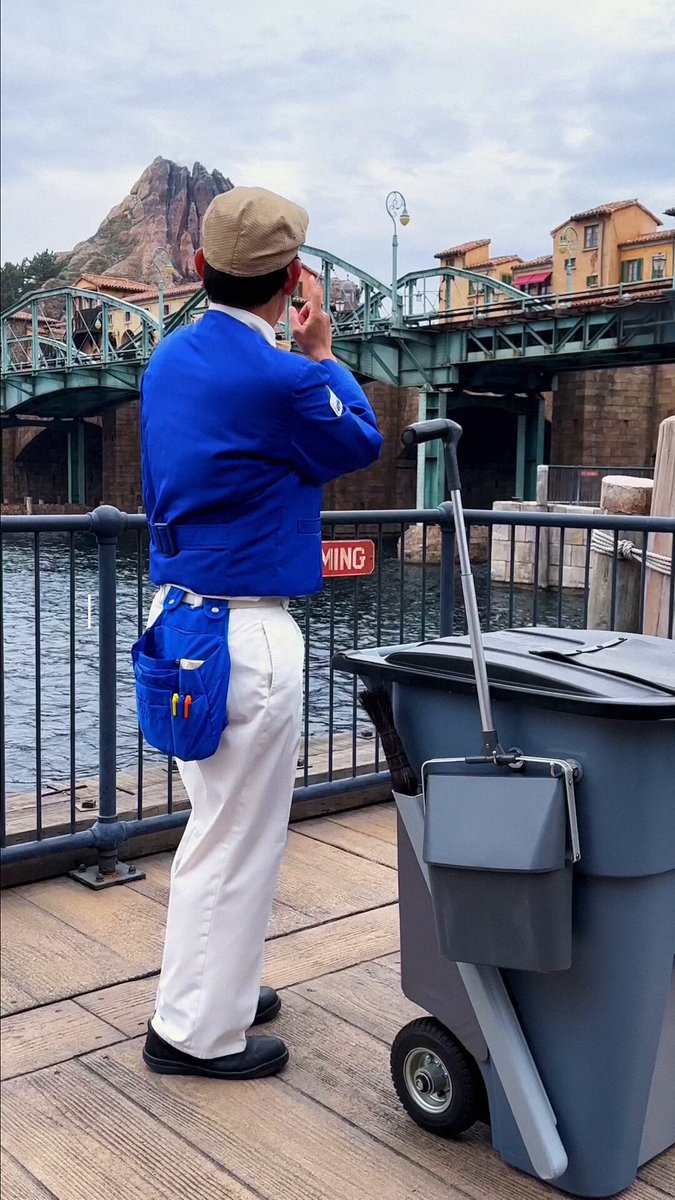 Tokyo DisneySea custodial Cast Member beside a cleaning cart at Mediterranean Harbor