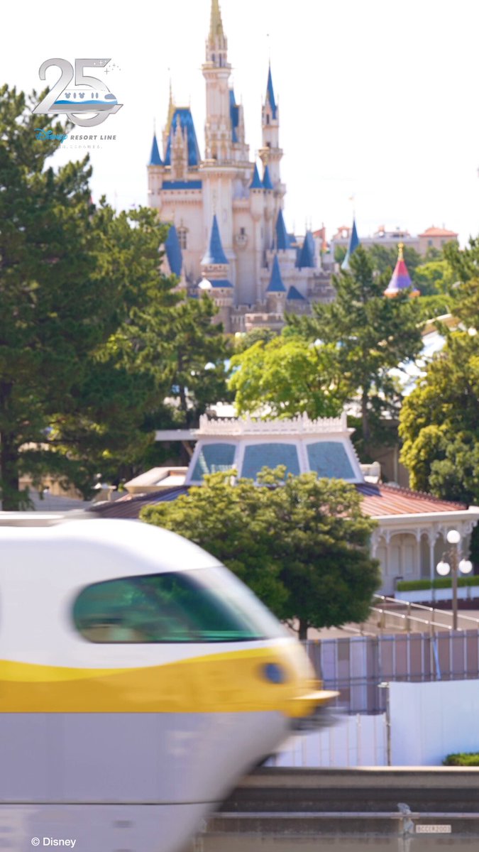 A yellow Disney Resort Line monorail passing Tokyo Disneyland during the line's 25th anniversary