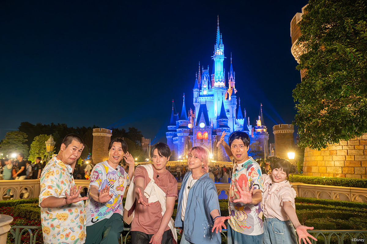 Television personalities pose in front of Cinderella Castle at Tokyo Disneyland