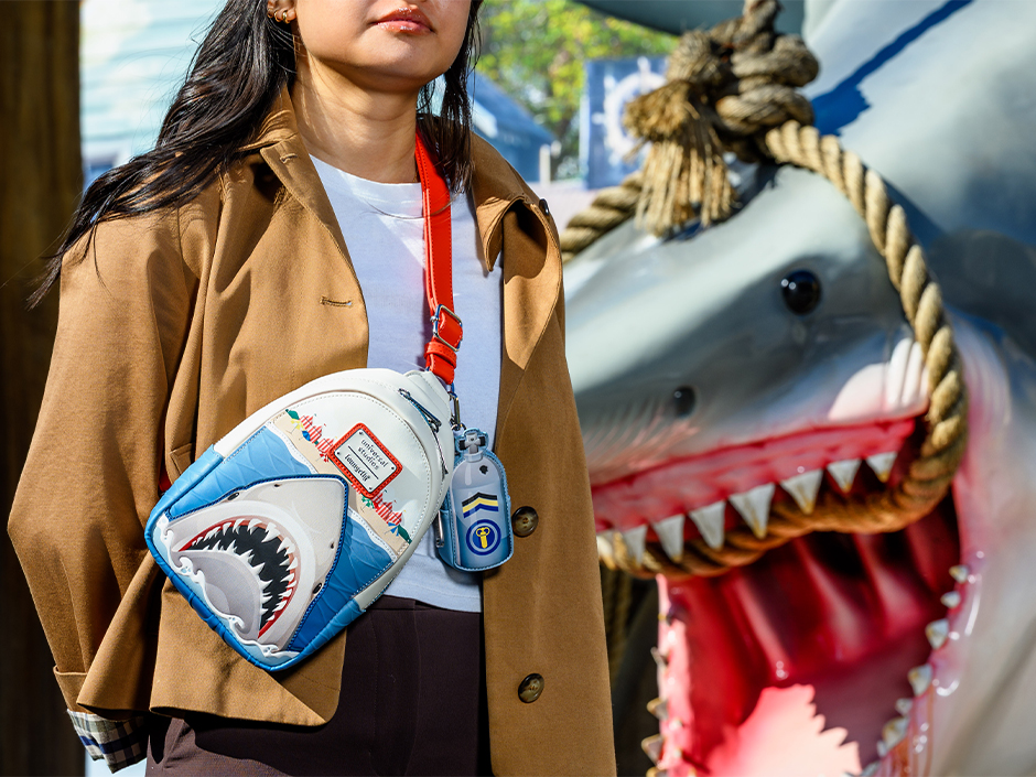 A guest posing beside a Bruce the shark display at Universal Studios Florida