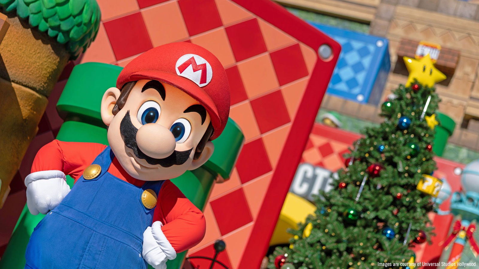 Mario beside a decorated Christmas tree in Super Nintendo World