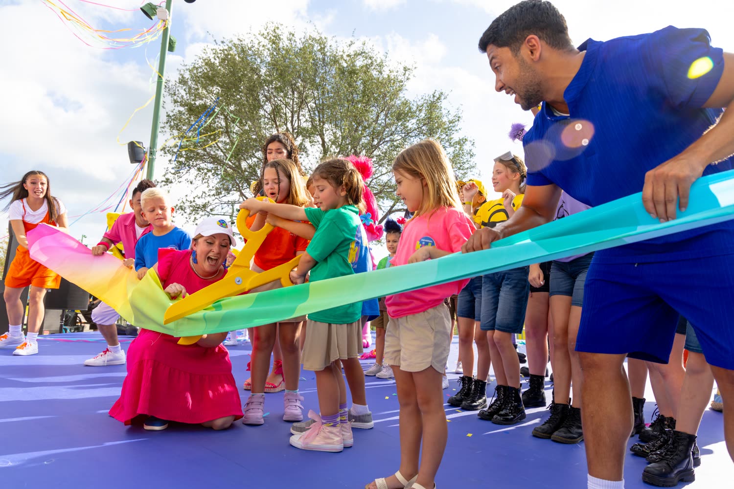 Children hold oversized scissors at the Universal Kids Resort opening-day celebration