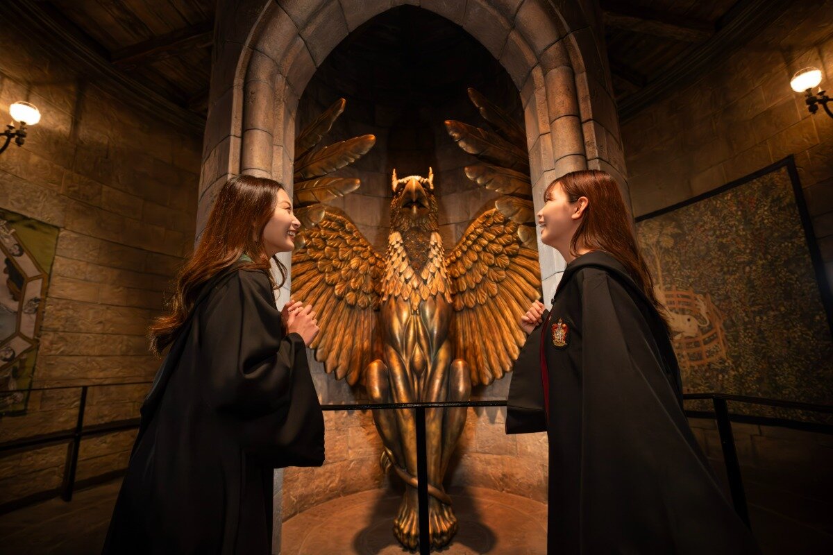 Guests view a griffin statue during Hogwarts Castle Walk at Universal Studios Japan