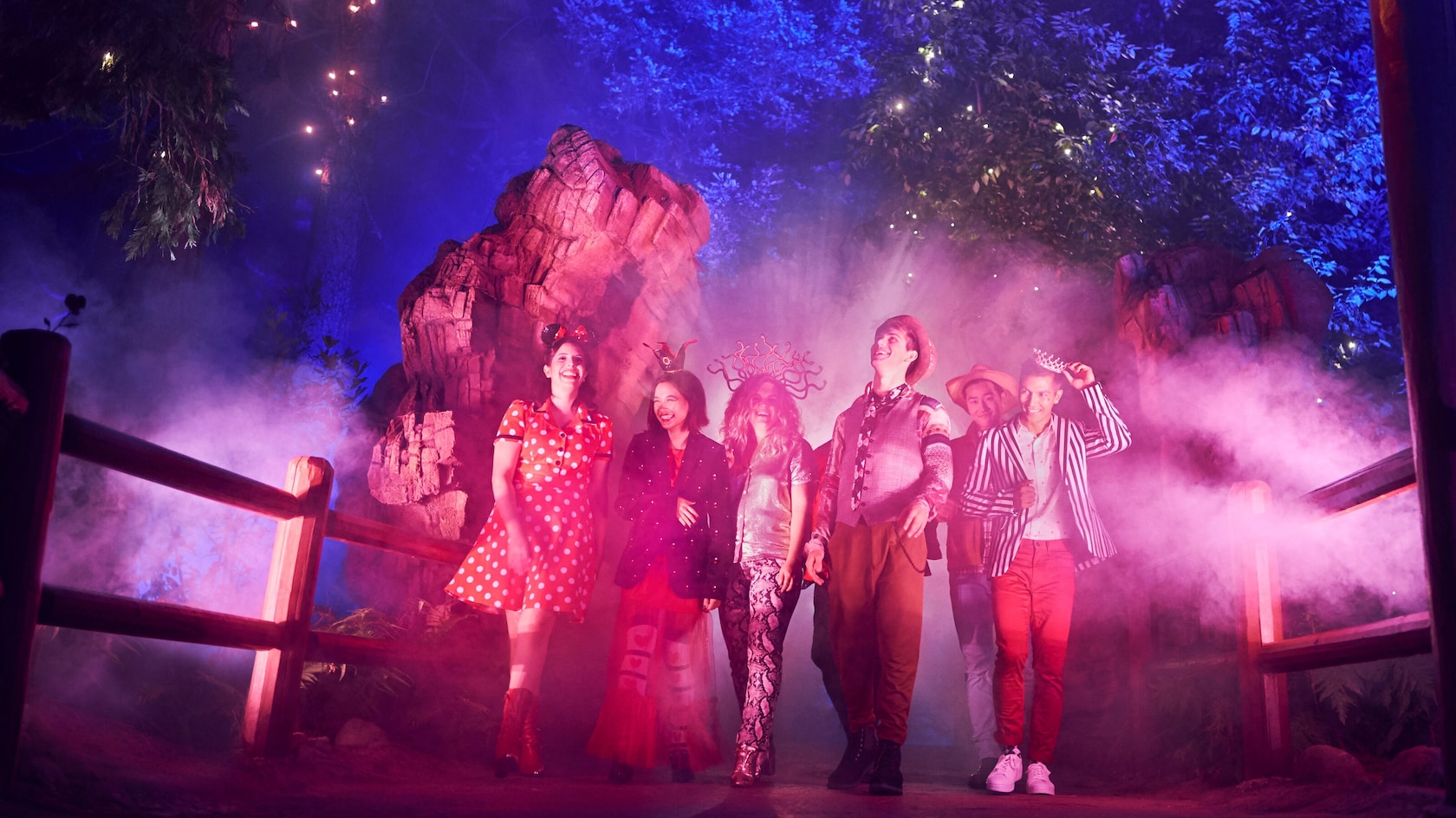Guests walk through the mist and colored light of Villains Grove at Disney California Adventure